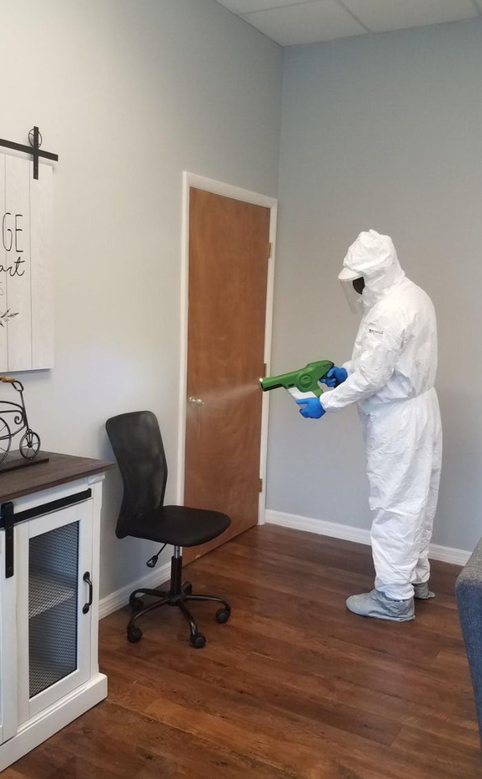 Kings technician in protective suit disinfecting an office